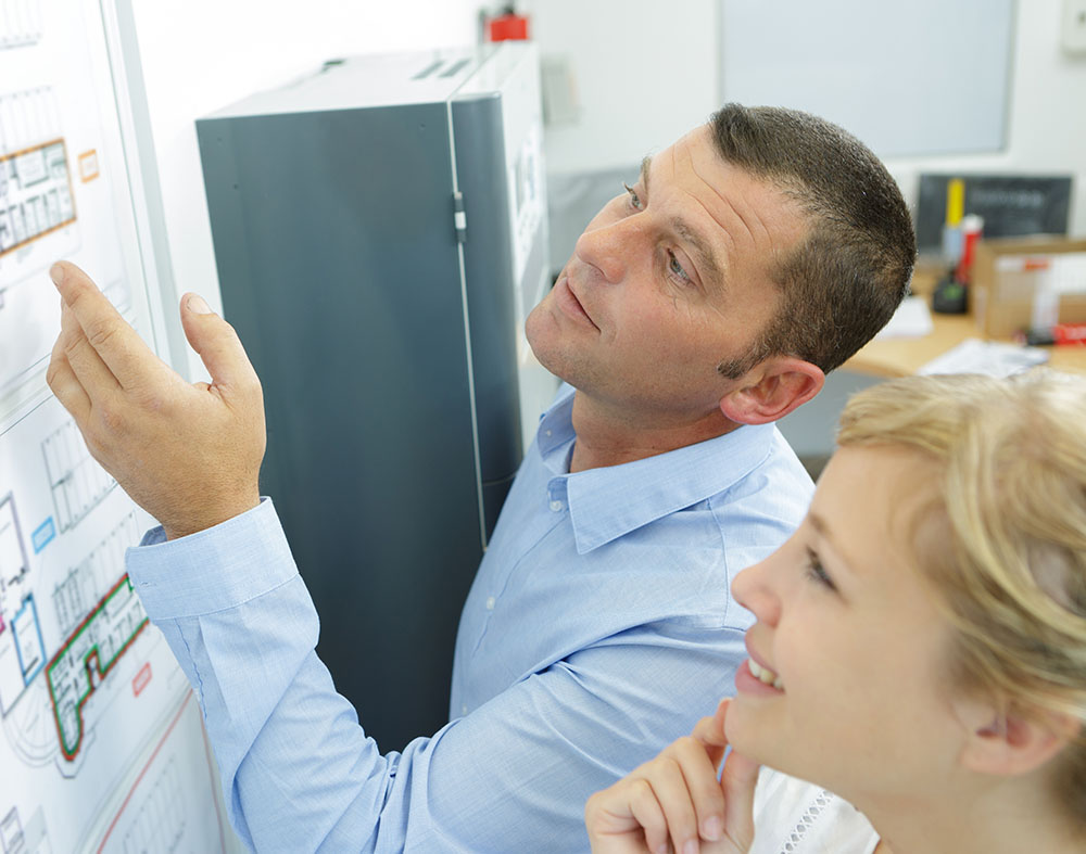 a man and woman looking at a fire safety plan